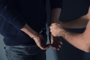 Man putting handcuffs on drug dealer, closeup view