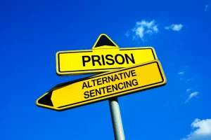 Prison or Alternative sentencing - Traffic sign with two options - Sentence as treatment or punishment. Effort to rehabilitate criminal and defendant. Prevention against relapse and recidivism